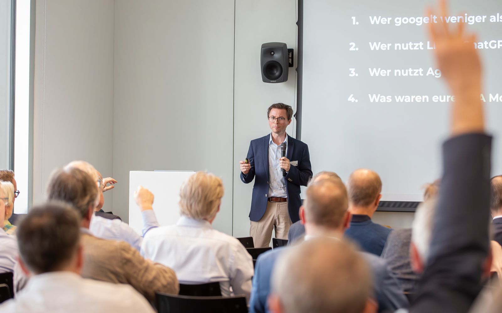 Hendrik Henze im Austausch mit dem Publikum; mehrere Teilnehmende melden sich per Handzeichen