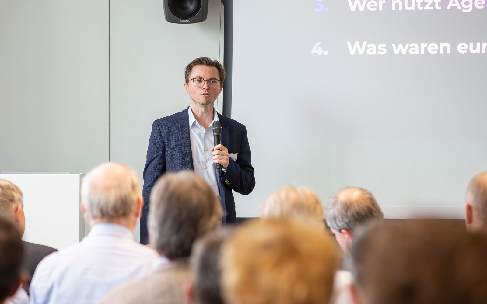 Hendrik Henze spricht mit Mikrofon vor dem Publikum beim TCI-Partnermeeting